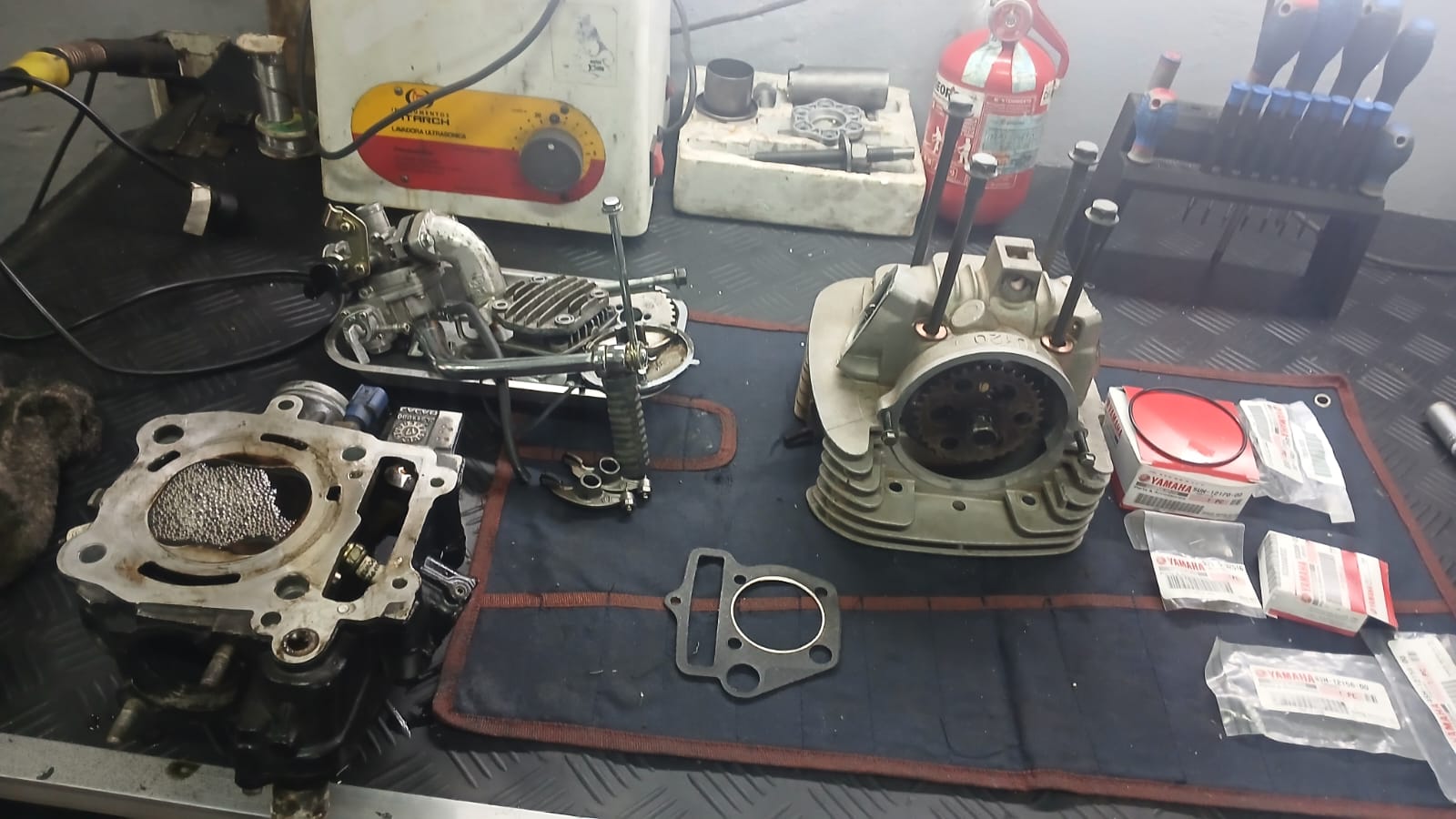 Culatas y repuestos originales Yamaha sobre la mesa de trabajo