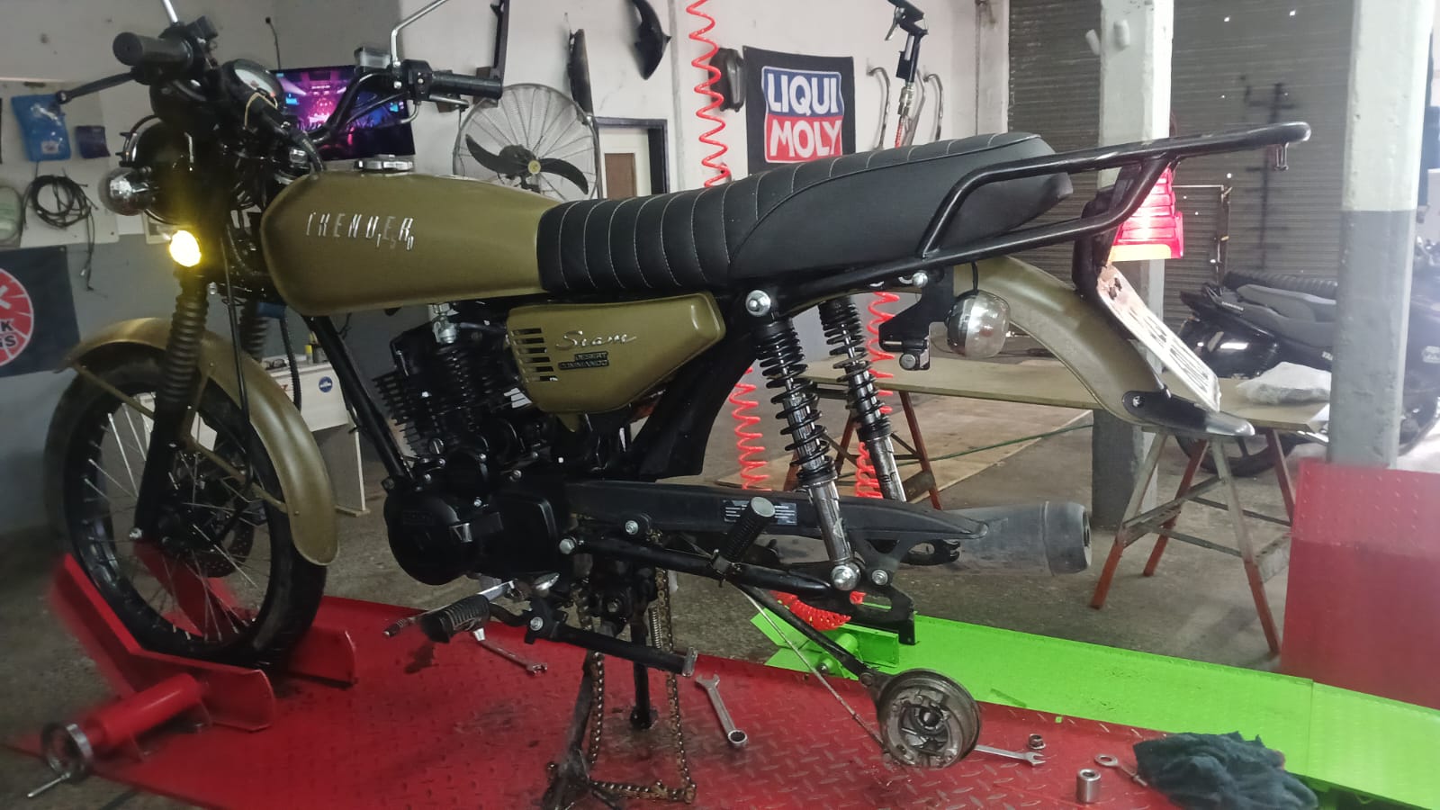 Moto café racer en restauración sobre el elevador